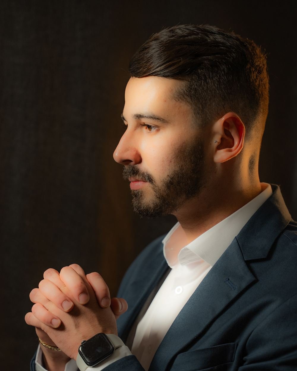 Dr. Luís Felipe de perfil, de terno, com as mãos unidas